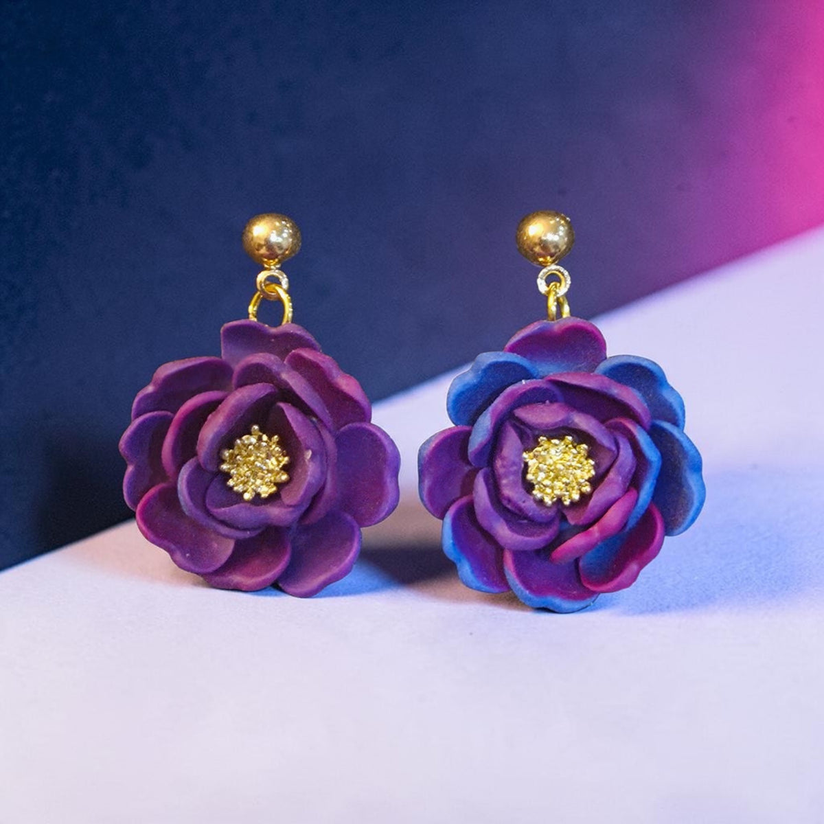 Layered purple, magenta, and blue polymer clay flower dangle earrings with gold-tone centers and ball stud tops